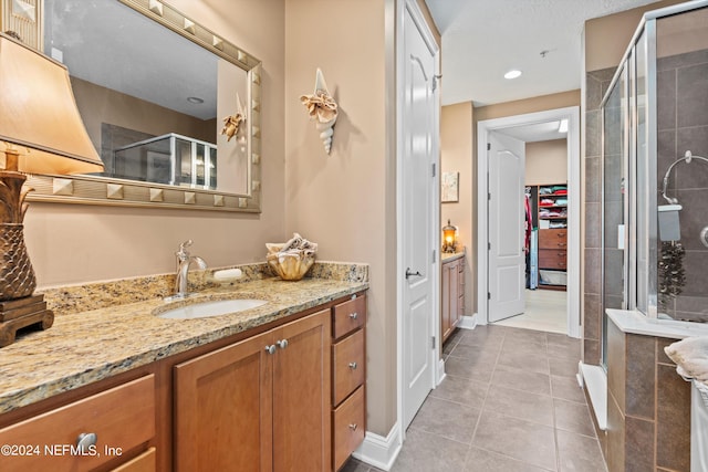 bathroom with tile patterned flooring, vanity, and an enclosed shower