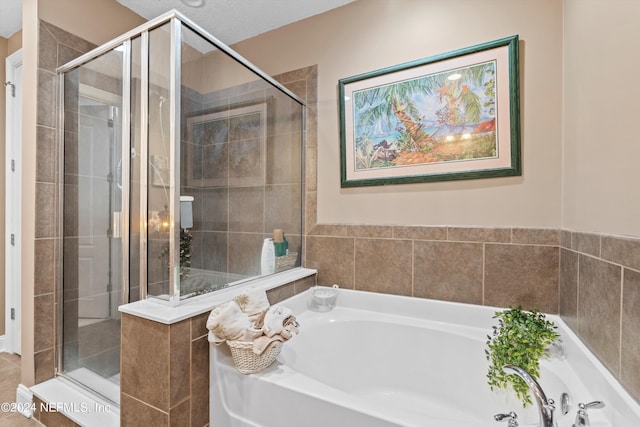 bathroom with plus walk in shower and a textured ceiling