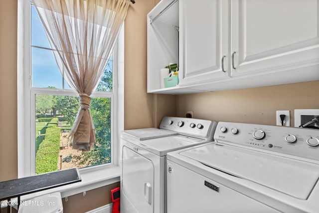 laundry room with washing machine and clothes dryer and cabinets