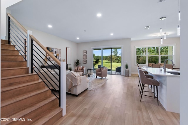 living room featuring light wood-type flooring and sink