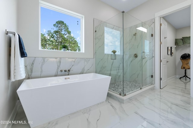 bathroom featuring shower with separate bathtub and tile walls