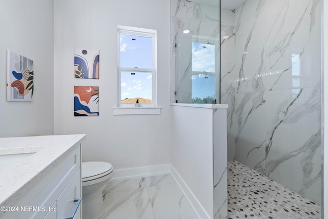 bathroom featuring toilet, vanity, and tiled shower