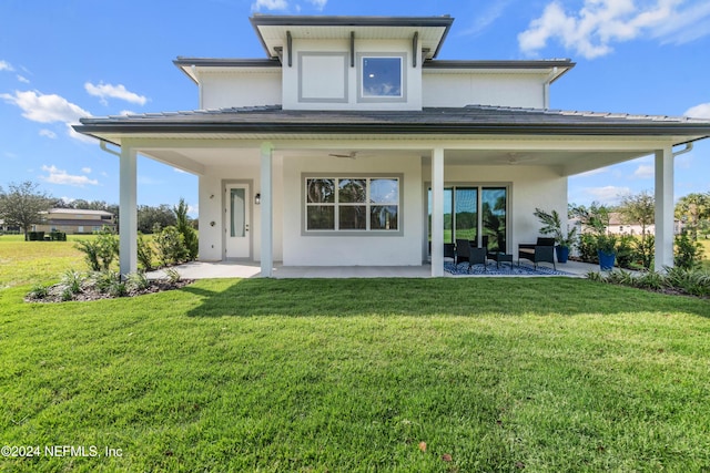 back of property with a yard and a patio area