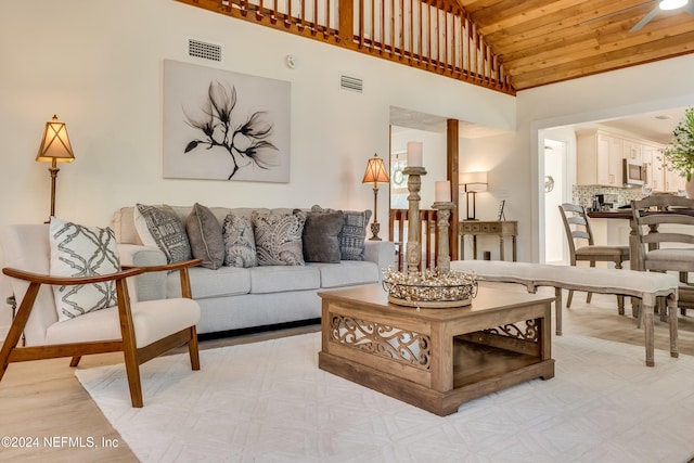 living room featuring high vaulted ceiling and wooden ceiling