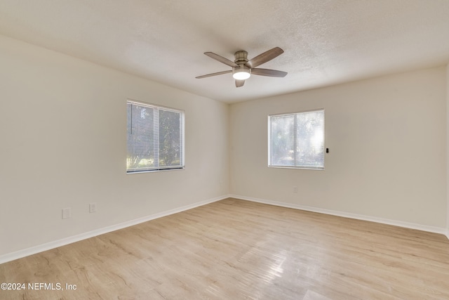 empty room with ceiling fan, light hardwood / wood-style floors, and plenty of natural light