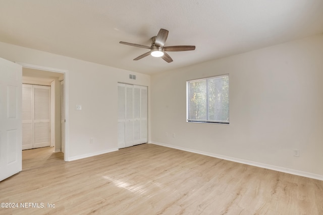 empty room with ceiling fan and light hardwood / wood-style floors