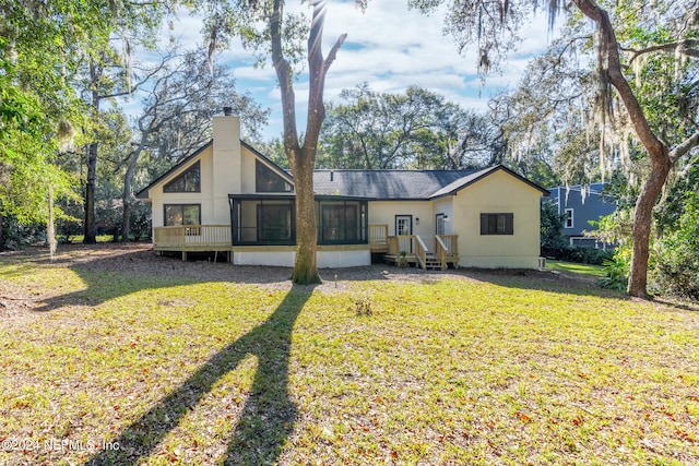 rear view of property with a sunroom and a lawn