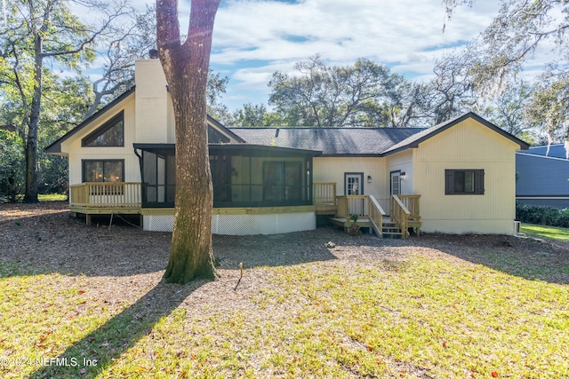 rear view of property with a yard and a sunroom