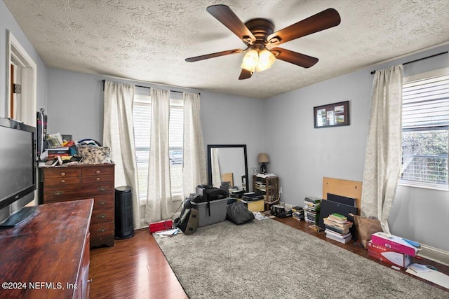 playroom featuring a textured ceiling, dark hardwood / wood-style flooring, and ceiling fan