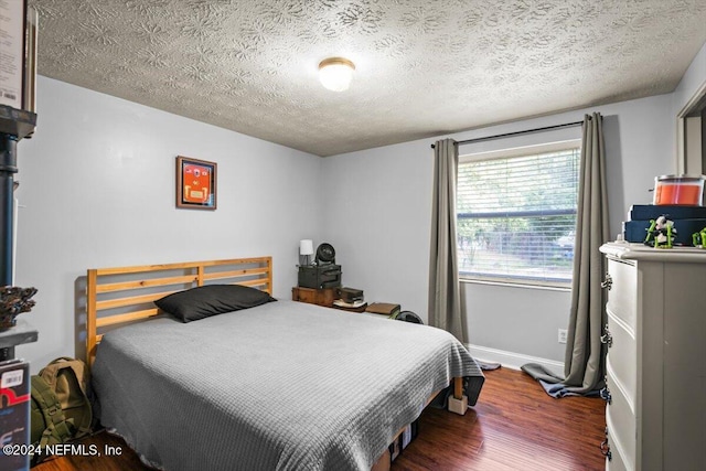 bedroom featuring a textured ceiling and dark wood-type flooring