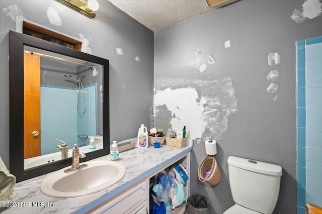 bathroom featuring vanity, toilet, a textured ceiling, and walk in shower