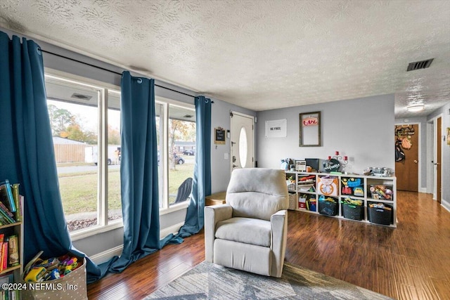 living area featuring hardwood / wood-style flooring and a textured ceiling