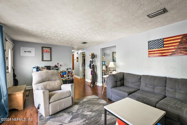 living room featuring dark hardwood / wood-style flooring and a textured ceiling