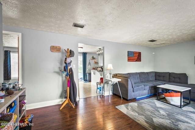 living room featuring dark hardwood / wood-style flooring and a textured ceiling