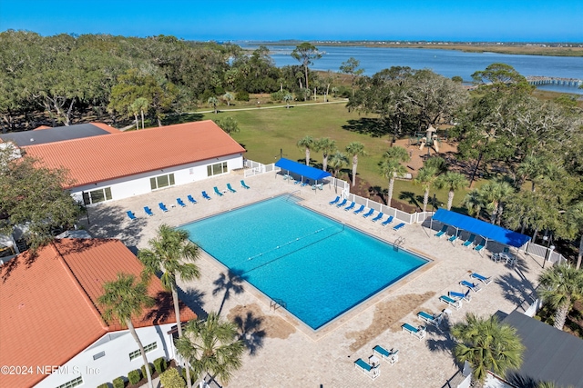 view of swimming pool featuring a water view and a patio area