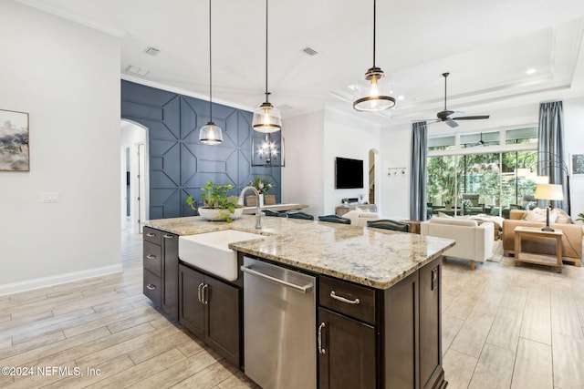 kitchen featuring dishwasher, a center island with sink, sink, hanging light fixtures, and ceiling fan