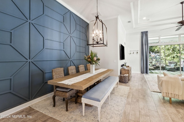 dining room featuring ceiling fan with notable chandelier, light hardwood / wood-style floors, and ornamental molding