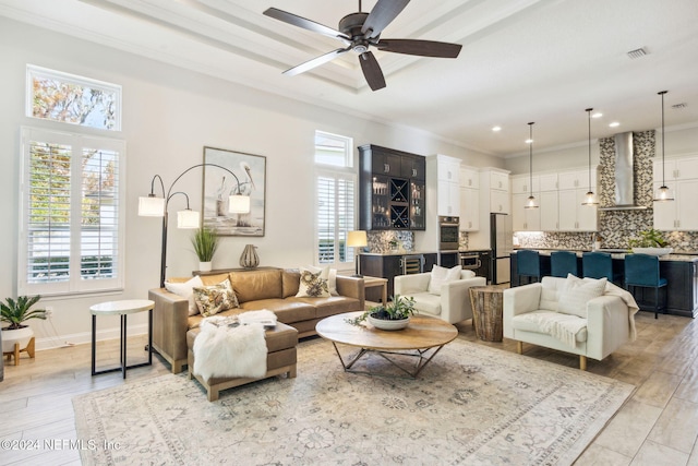 living room with light hardwood / wood-style flooring, ceiling fan, and ornamental molding