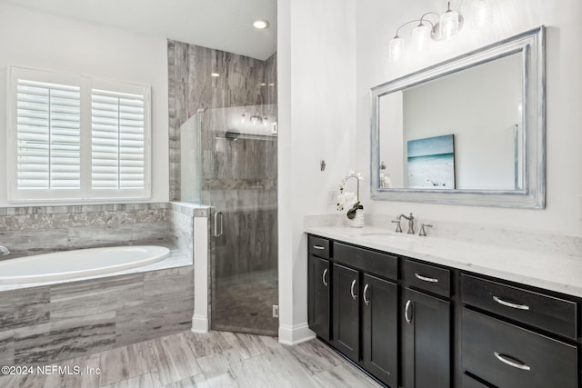 bathroom with vanity and shower with separate bathtub