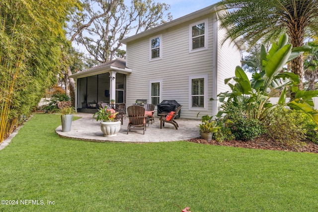 back of house featuring a lawn, a sunroom, and a patio