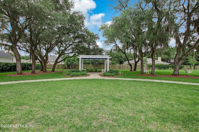 view of community featuring a pergola and a yard