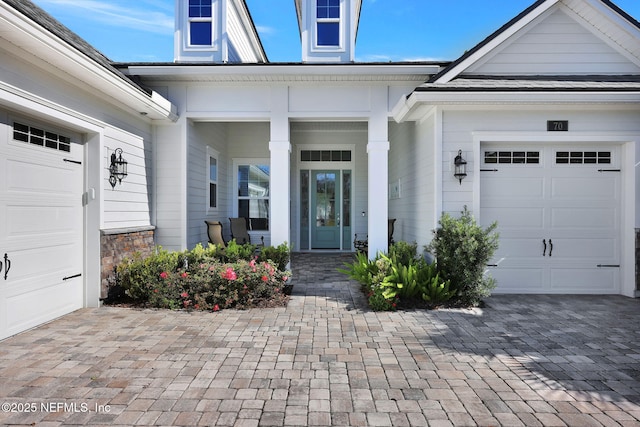 entrance to property with a garage and covered porch