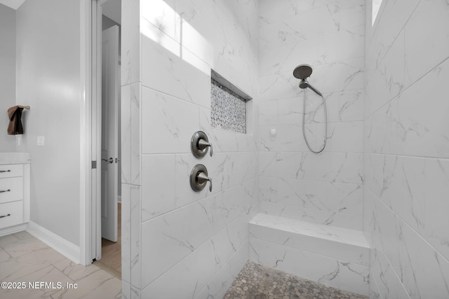 bathroom featuring a tile shower and vanity