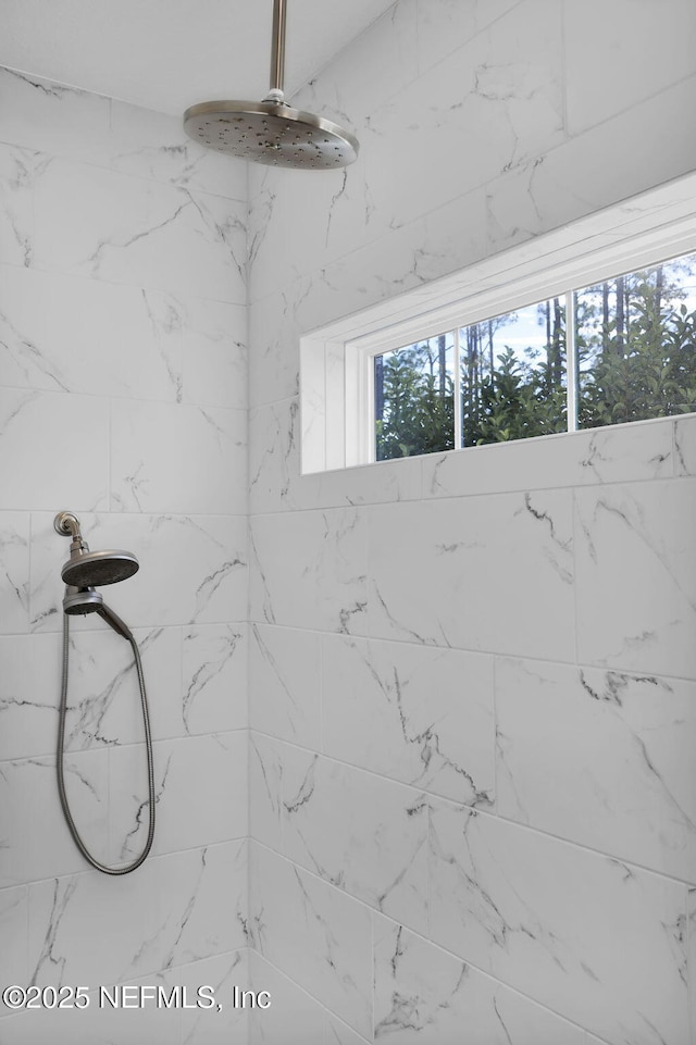 interior details featuring a tile shower