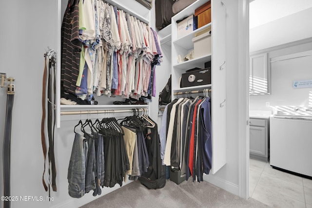 walk in closet featuring light colored carpet