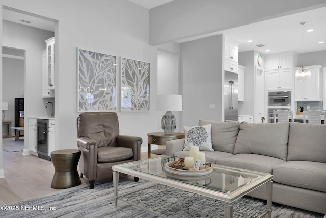 living room featuring wine cooler and light wood-type flooring