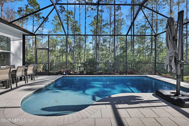 view of pool with glass enclosure and a patio