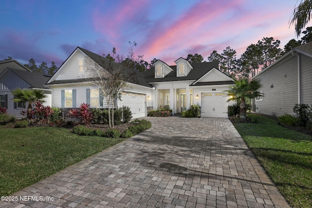 view of front of home with a garage and a yard