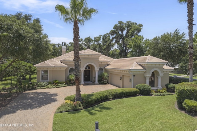 mediterranean / spanish-style house with a front yard and a garage