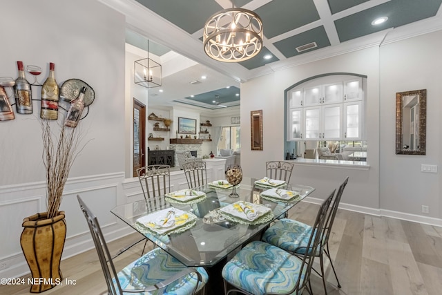 dining room with coffered ceiling, crown molding, light wood-type flooring, beamed ceiling, and a notable chandelier