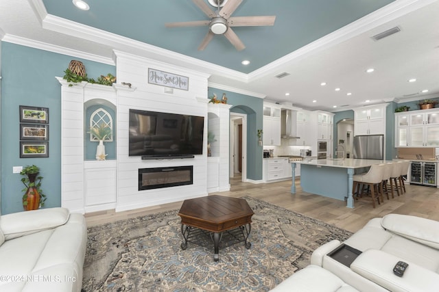 101 Montura Dr, Ponte Vedra Beach, FL 32082 - living area featuring light wood-style flooring, a ceiling fan, recessed lighting, crown molding, and a large fireplace