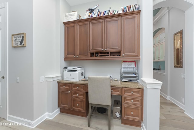 office area with built in desk and light hardwood / wood-style flooring