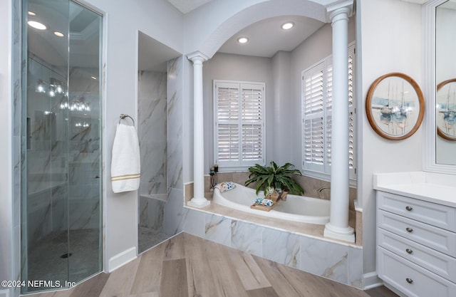 bathroom featuring decorative columns, vanity, independent shower and bath, and hardwood / wood-style flooring