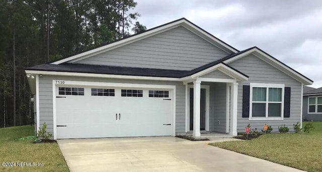 view of front of home with a garage and a front lawn