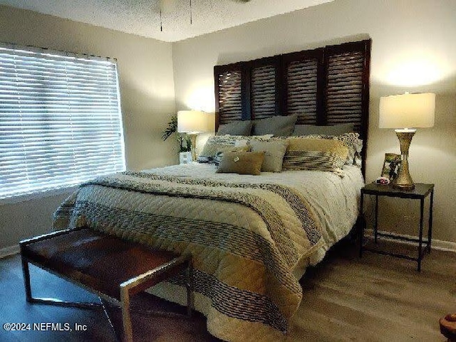 bedroom featuring wood-type flooring and a textured ceiling