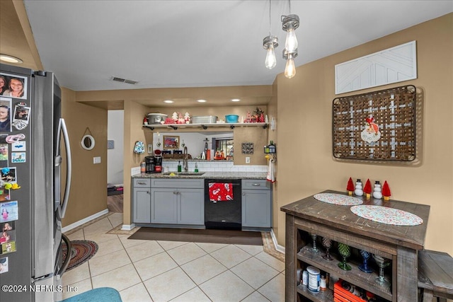 kitchen with gray cabinetry, sink, light tile patterned floors, black dishwasher, and stainless steel refrigerator