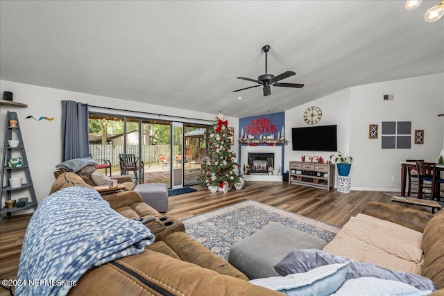 living room with a textured ceiling, hardwood / wood-style flooring, ceiling fan, and lofted ceiling