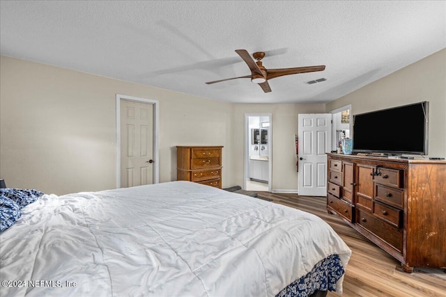 bedroom featuring hardwood / wood-style flooring, ceiling fan, and a textured ceiling