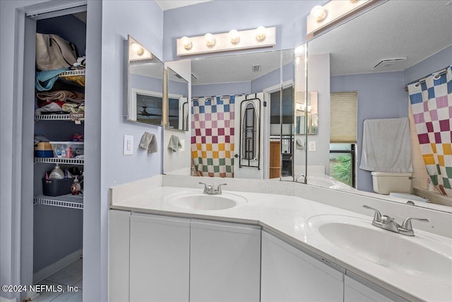 bathroom featuring vanity, a textured ceiling, and walk in shower