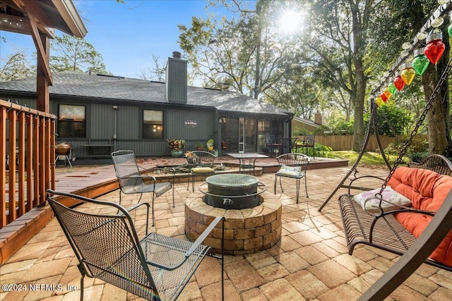 view of patio / terrace with a fire pit and a sunroom