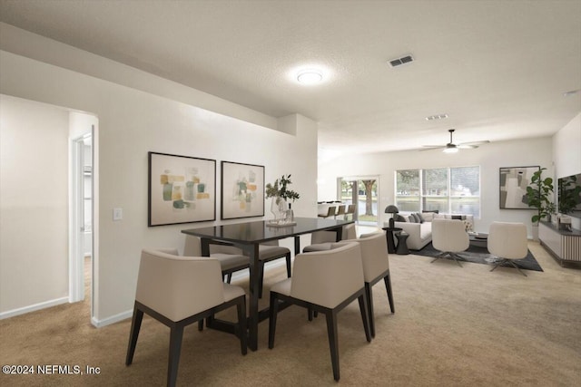 dining area with light colored carpet, visible vents, and baseboards