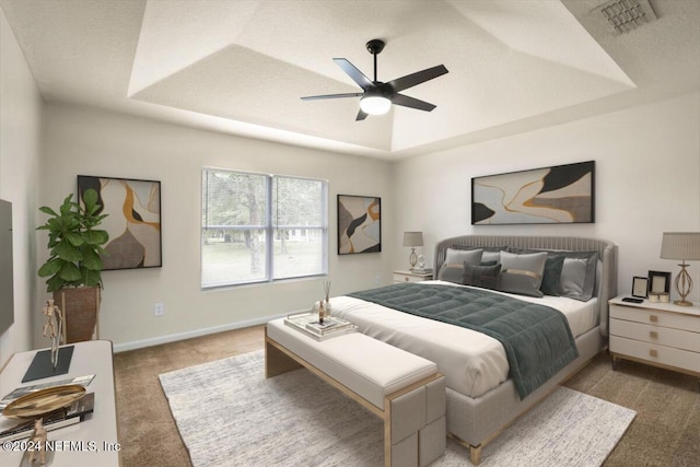 bedroom featuring carpet, a textured ceiling, a tray ceiling, and ceiling fan