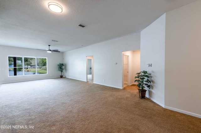 spare room featuring visible vents, carpet flooring, a textured ceiling, and baseboards