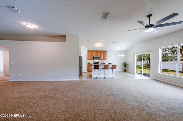 unfurnished living room featuring visible vents, light colored carpet, and lofted ceiling