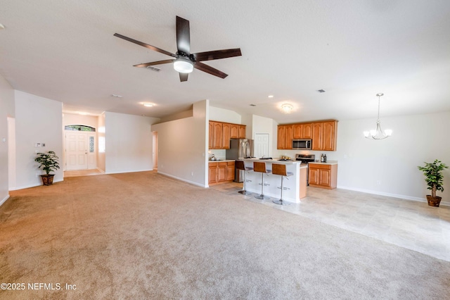 unfurnished living room with light carpet, ceiling fan with notable chandelier, baseboards, and lofted ceiling