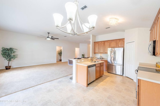 kitchen featuring a center island with sink, a sink, light countertops, appliances with stainless steel finishes, and light colored carpet